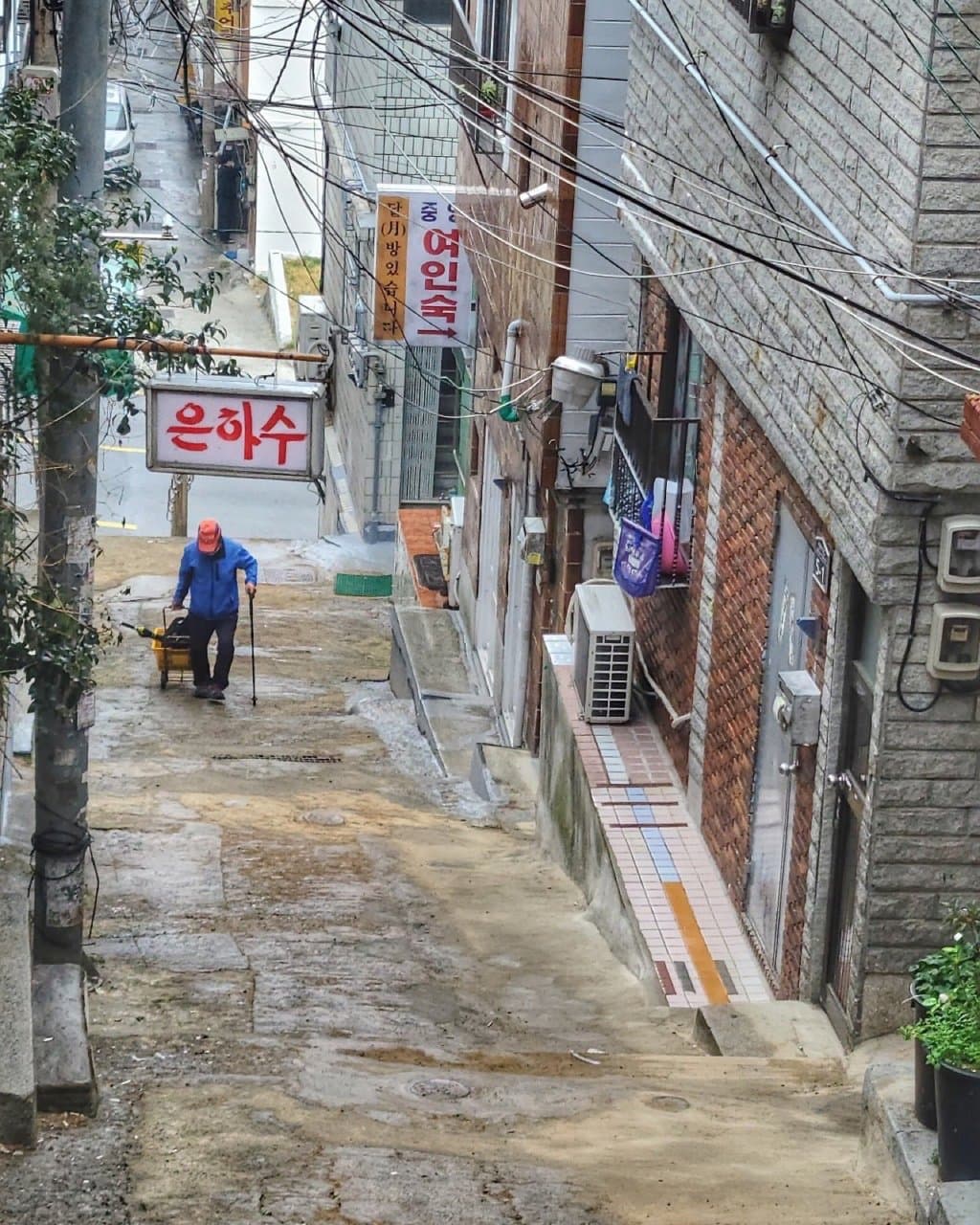 오르막 골목. 여인숙과 은하수 간판이 걸려 있다.